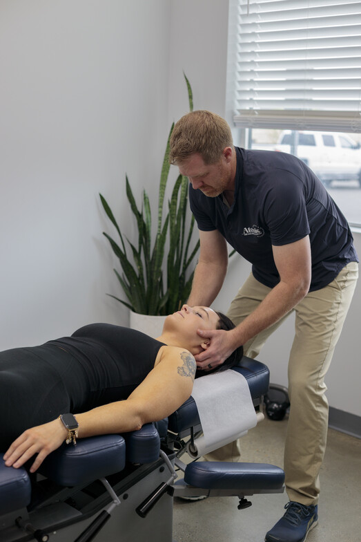 Chiropractor providing gentle neck adjustment for neck tension and tension headaches at Atomic Pilates & Chiropractic in Bluffdale Utah